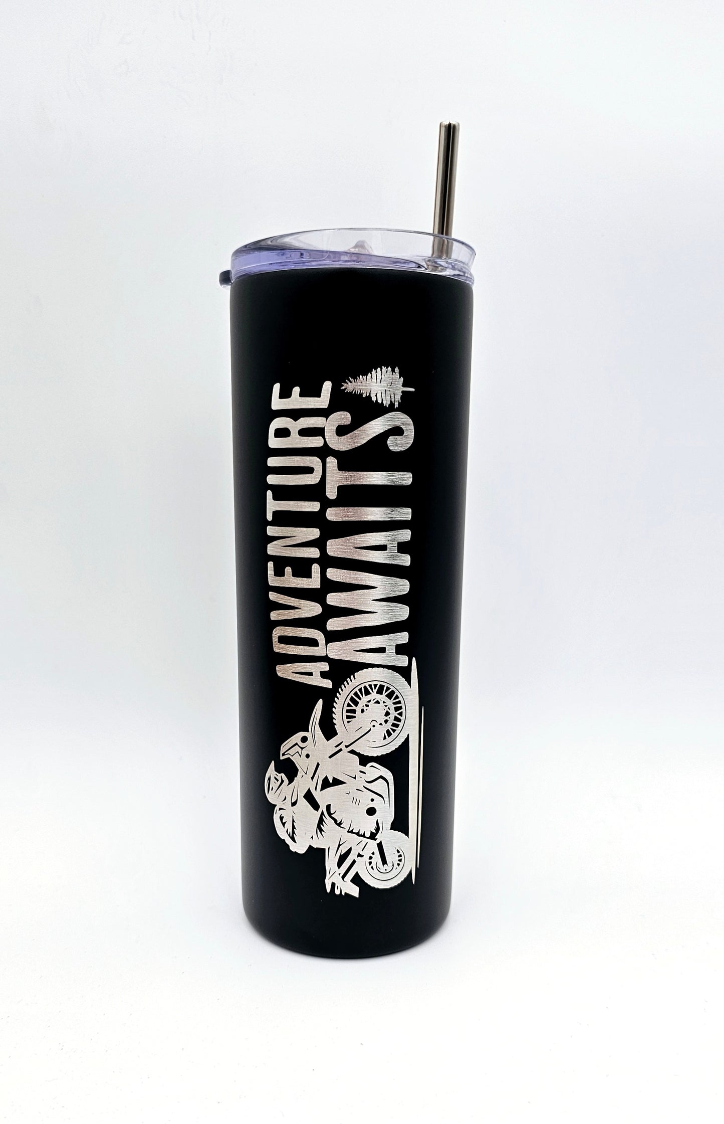 Laser engraved tumbler featuring a motorcycle and the text 'Adventure Awaits'. Standing upright, showcasing intricate design.